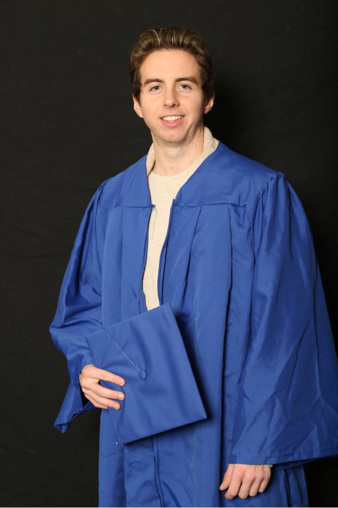 student poses with his graduation cap and gown